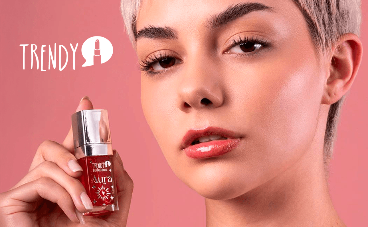 Trendy cosmetics with model holding red lip product on coral background